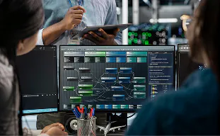Team reviewing an automated workflow dashboard on multiple screens