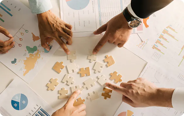 Team solving a business problem together with puzzle pieces over data reports