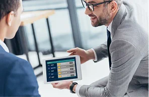 Two colleagues reviewing an integrated dashboard on a tablet